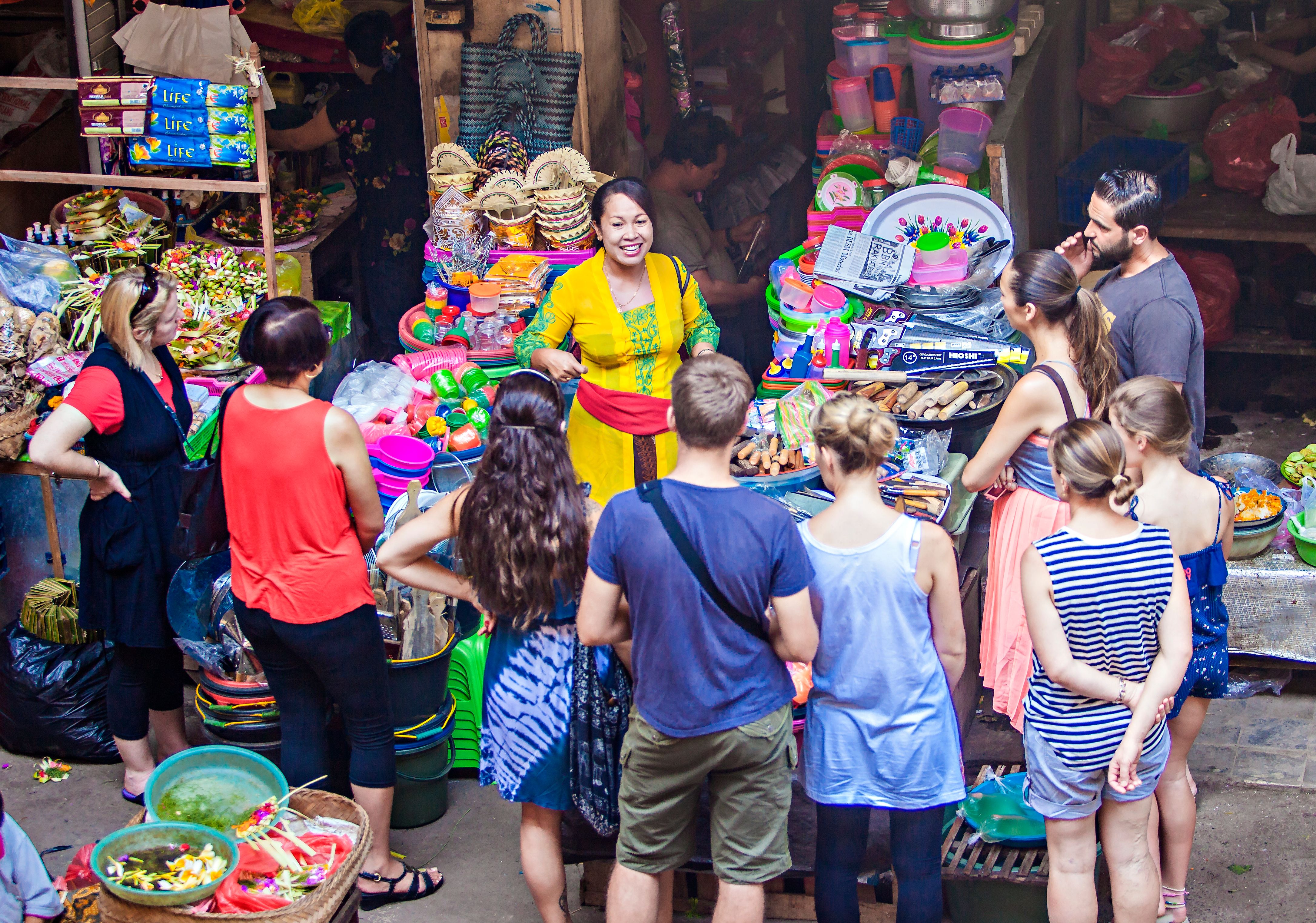 Seorang tourist guide sedang menjelaskan karya kriya yang dijajakan di sebuah pasar di Ubud Bali. (Foto: Shutterstock/Sony Herdiana)