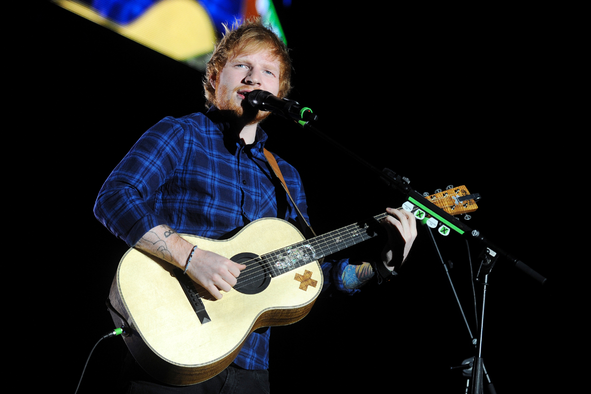 Foto: Penampilan khas Ed Sheeran dengan gitar akustik andalannya (Shutterstock/yakub88)